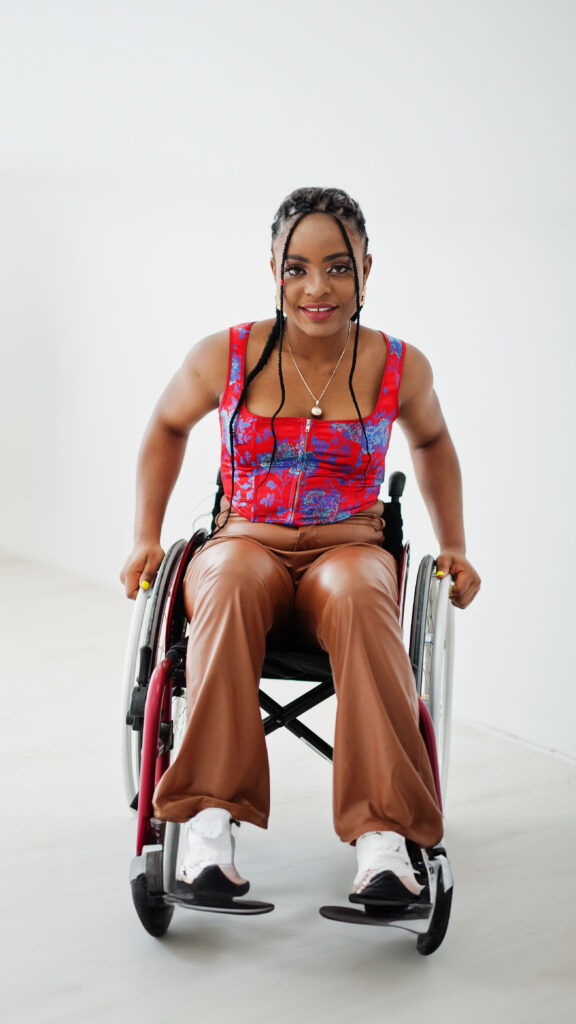 Mujer joven afroamericana con discapacidad en silla de ruedas.


